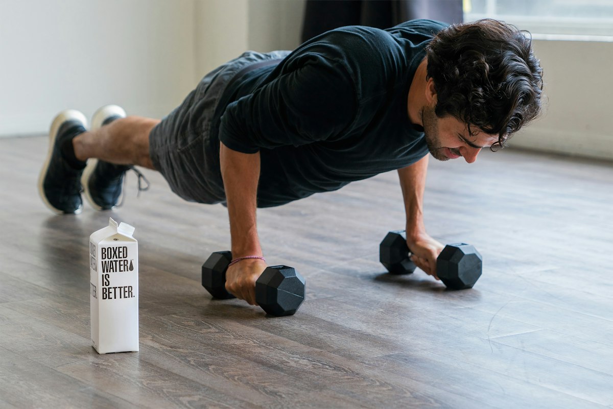 Man doing push-ups on dumbbells on a living room floor